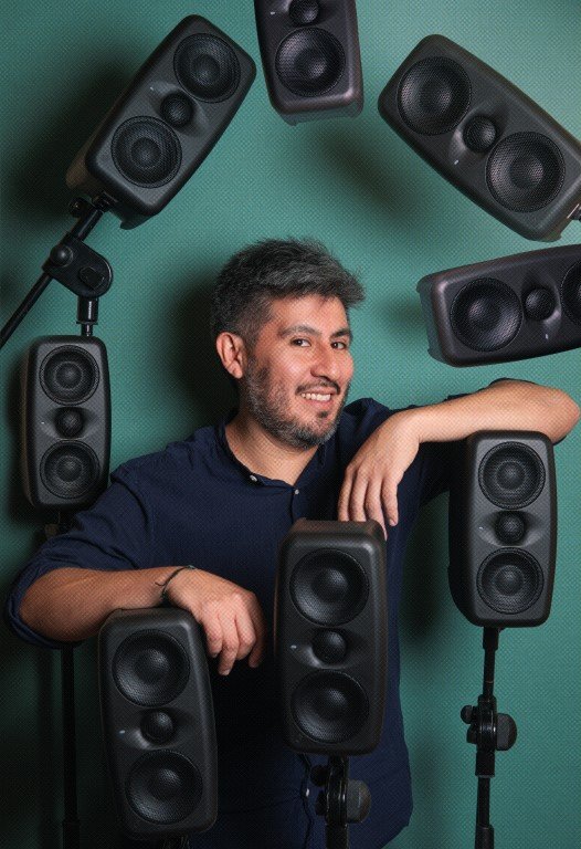 Especialista de sonido sonriente junto a parlantes